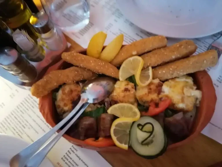 Panierter Lika-Käse, gebackene Champignons mit Prosciutto und Lika-Hüttenkäse, im Speckmantel gewendete Pflaumen