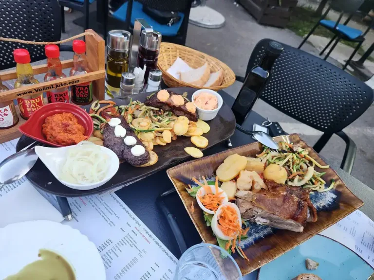 Gebratenes Spanferkel und gefüllte Pljeskavica in Lammfell gewickelt