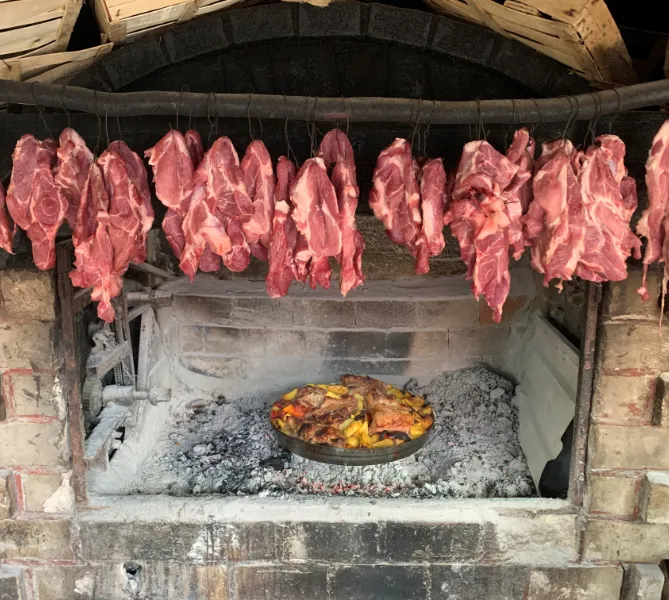 Räuchern von Schweinenacken und Kalbfleisch unter einer Peka